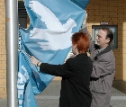 Petra Pau und Uwe Klett hissen die Friedensfahne am Rathaus Marzahn-Hellersdorf; Foto: Heidi Wagner